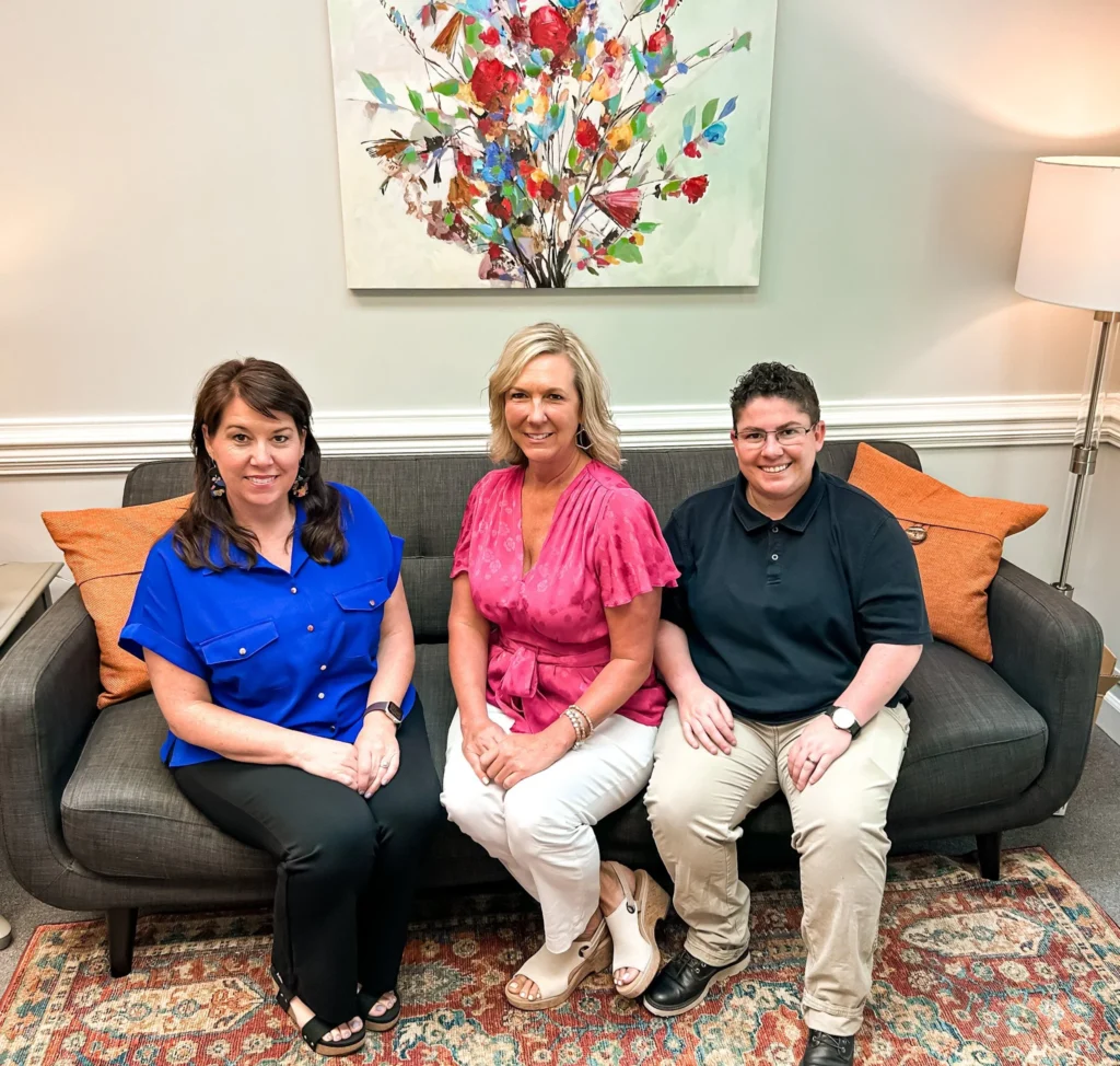 Three counselors seated on the waiting room sofa