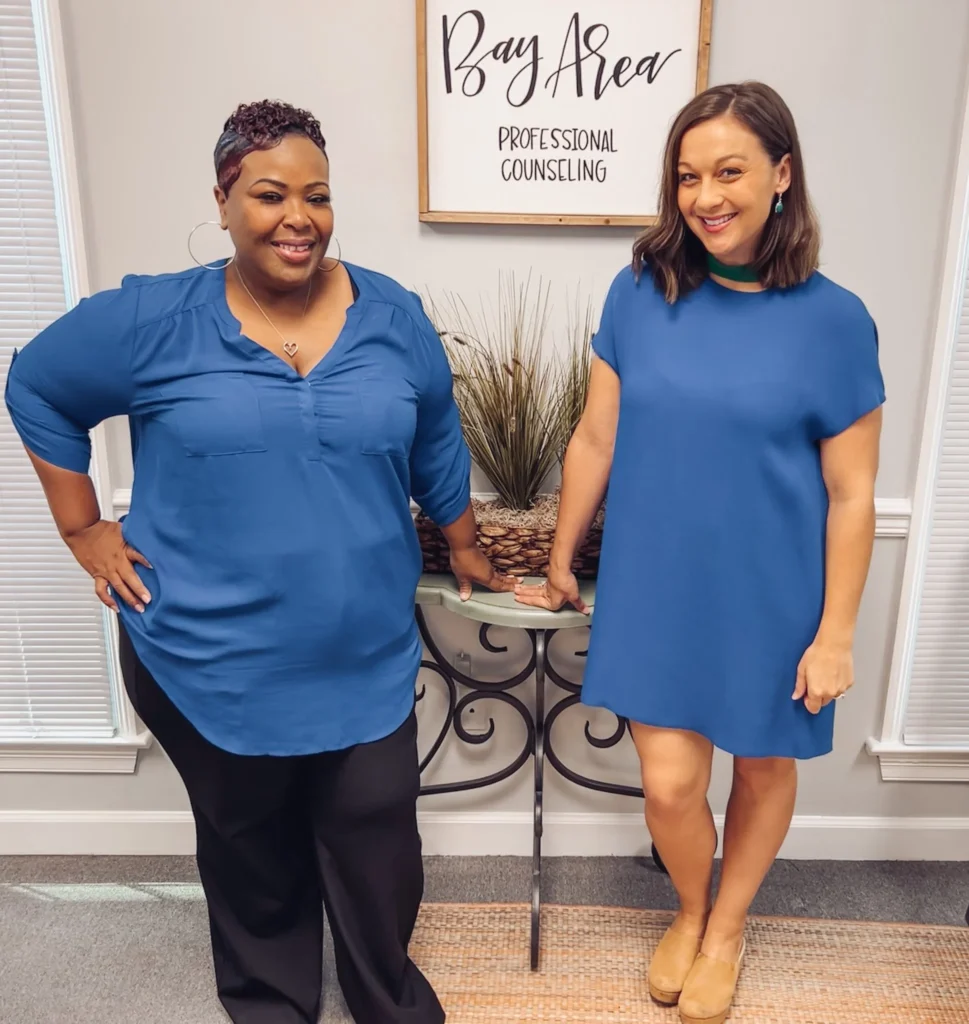 Two counselors beside the Bay Area Professional Counseling sign